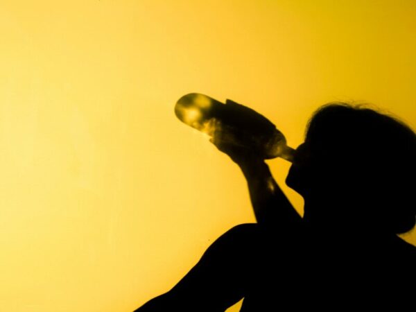Eine Frau trinkt aus einer Alkoholflasche