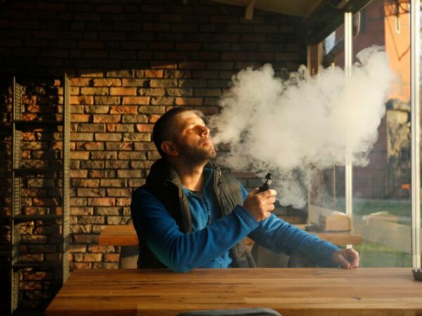 Kiffen im Café. Ein Mann sitzt mit einem Vape im einem Café. Ist das die Zukunft von modernen Konsumräumen?