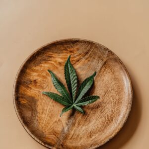CBD Isolat: grünes Hanfblatt auf einem Holzteller